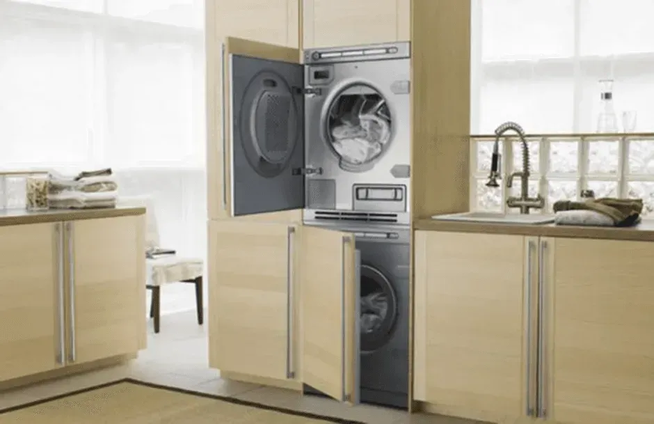 A washer and dryer are stacked on top of each other in a kitchen.