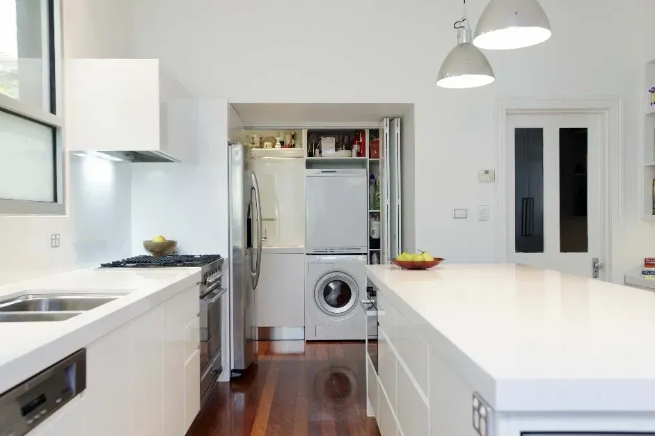 A kitchen with white cabinets and a washing machine