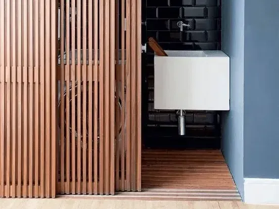A bathroom with a sink and a wooden sliding door
