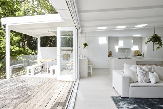 A living room with a couch , table , and sliding glass doors leading to a deck.
