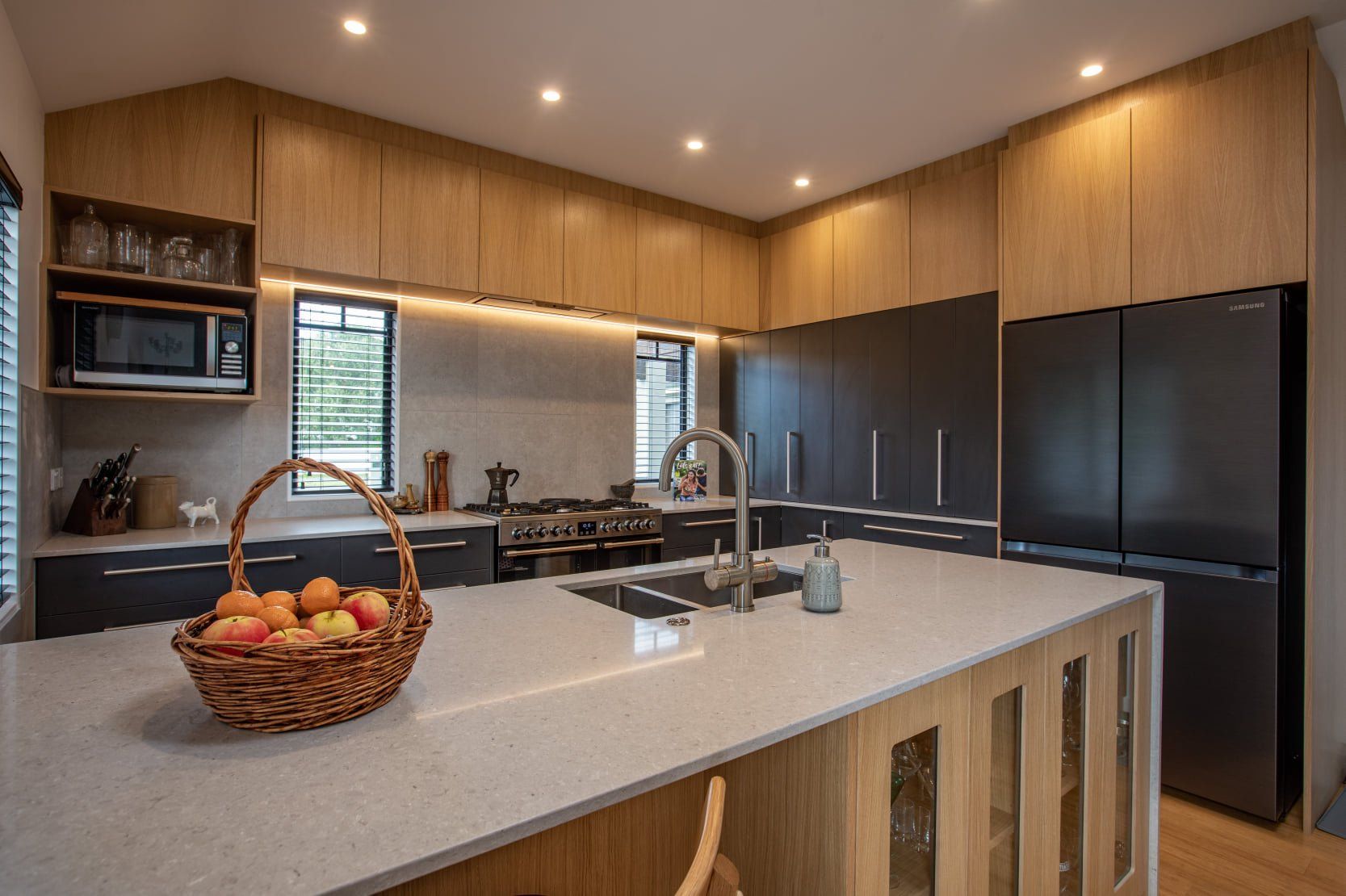 A kitchen with a basket of apples on the counter.