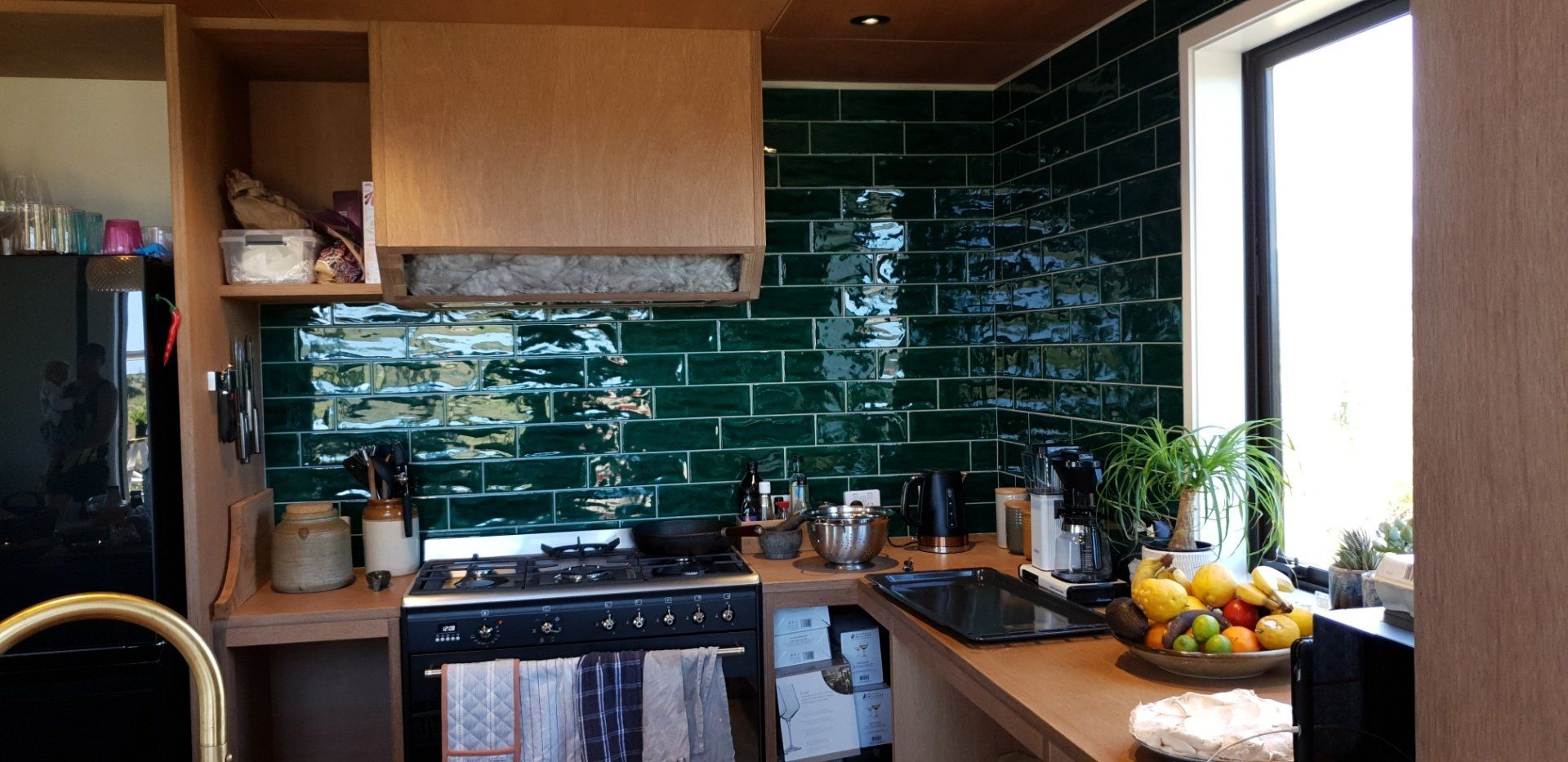 A small, modern bathroom with a dark vanity, vessel sink, chrome towel rack, toilet, and window with wooden blinds. 3D Model.