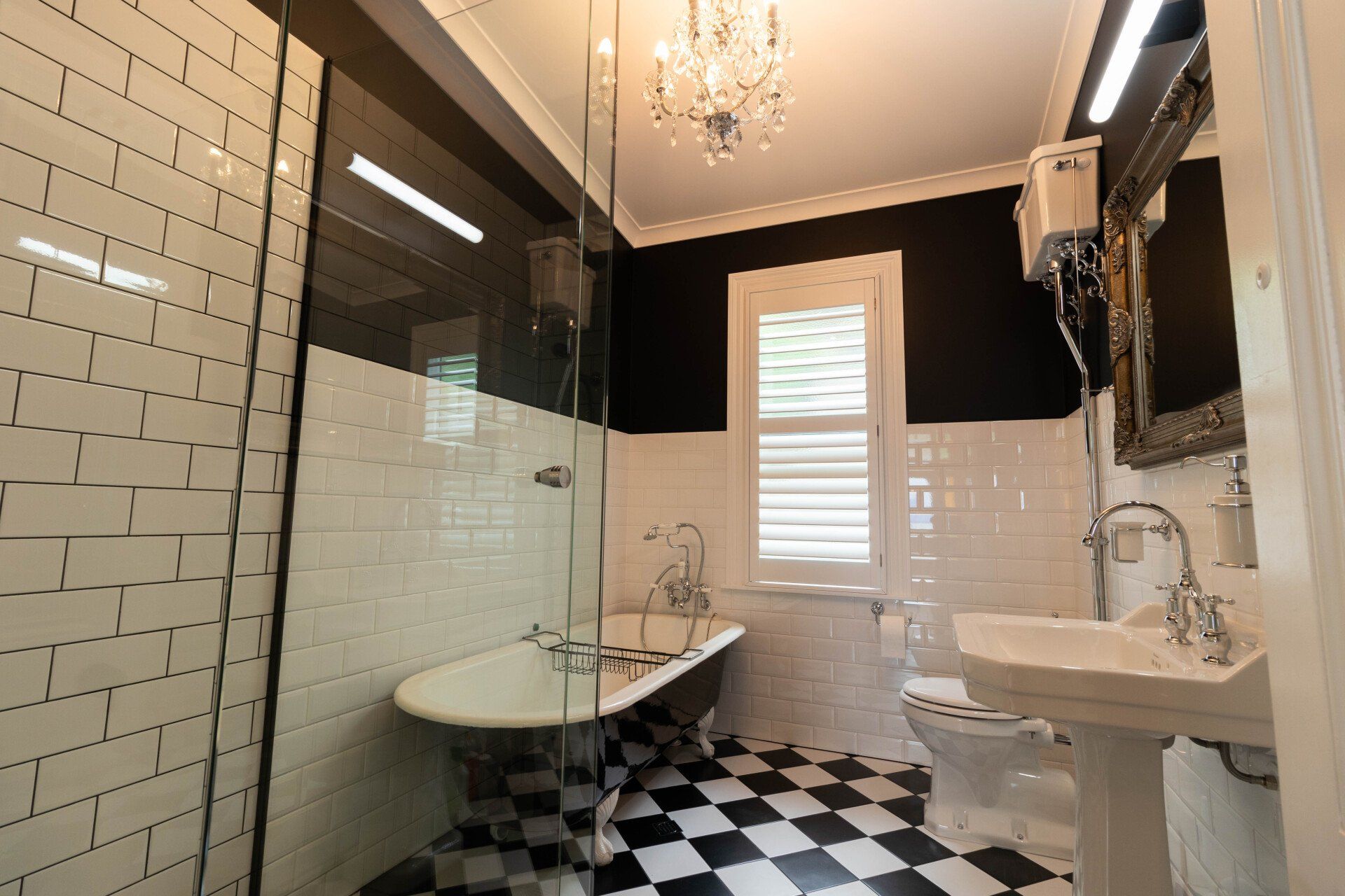 A bathroom with a bathtub , sink , toilet and checkered floor
