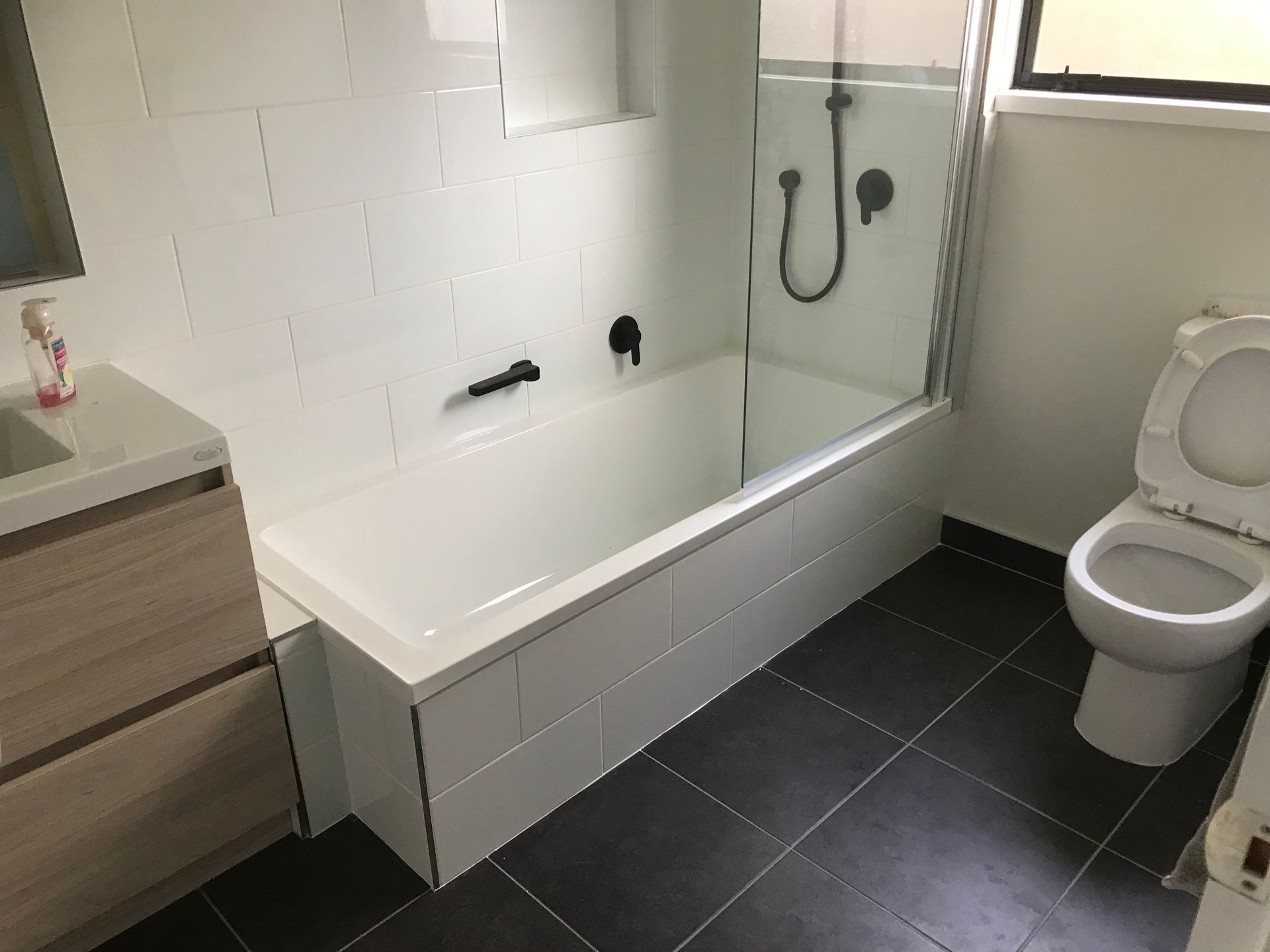 A bathroom with a toilet , sink and bathtub.