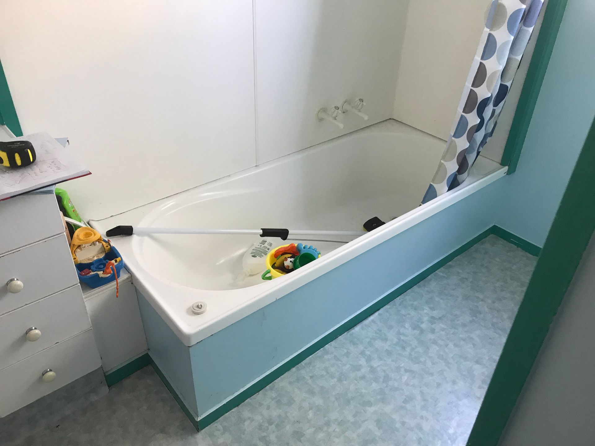 A bathroom with a bathtub and a dresser.