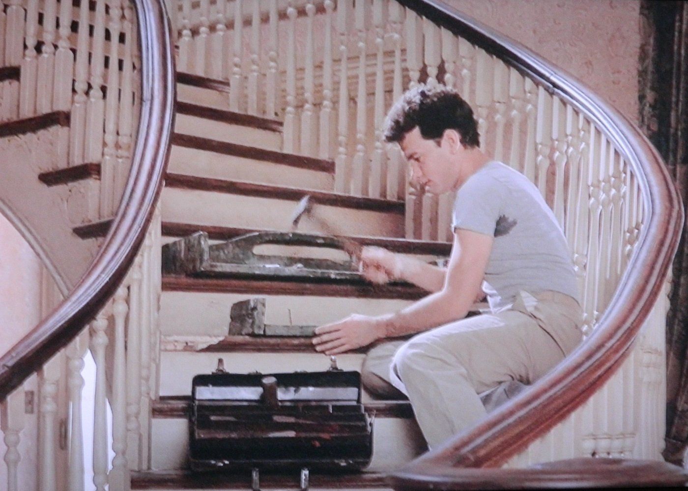 A man is working on a set of stairs with a hammer