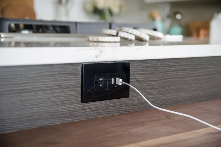 A kitchen counter with a charger plugged into it.