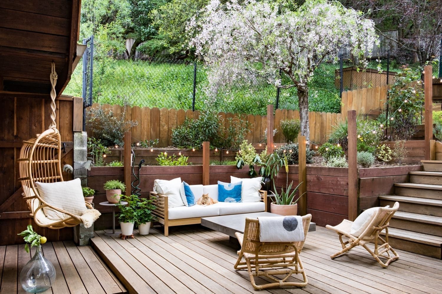 There is a wooden deck with a couch and chairs on it.