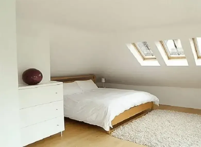 A bedroom with a bed and a dresser in it