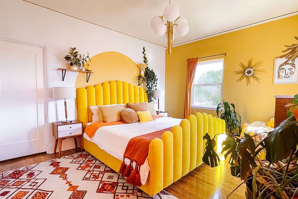 A bedroom with yellow walls and a yellow bed.