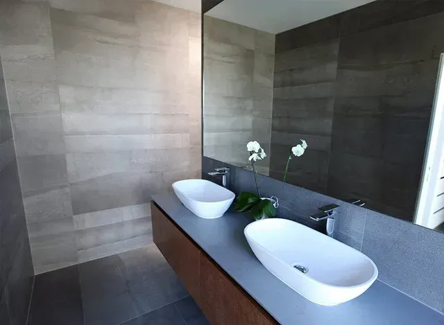 A bathroom with two sinks and a large mirror