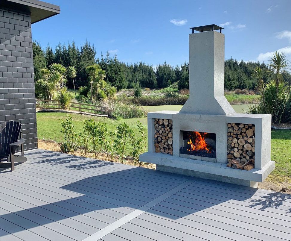A patio with a fireplace and a chair in the background