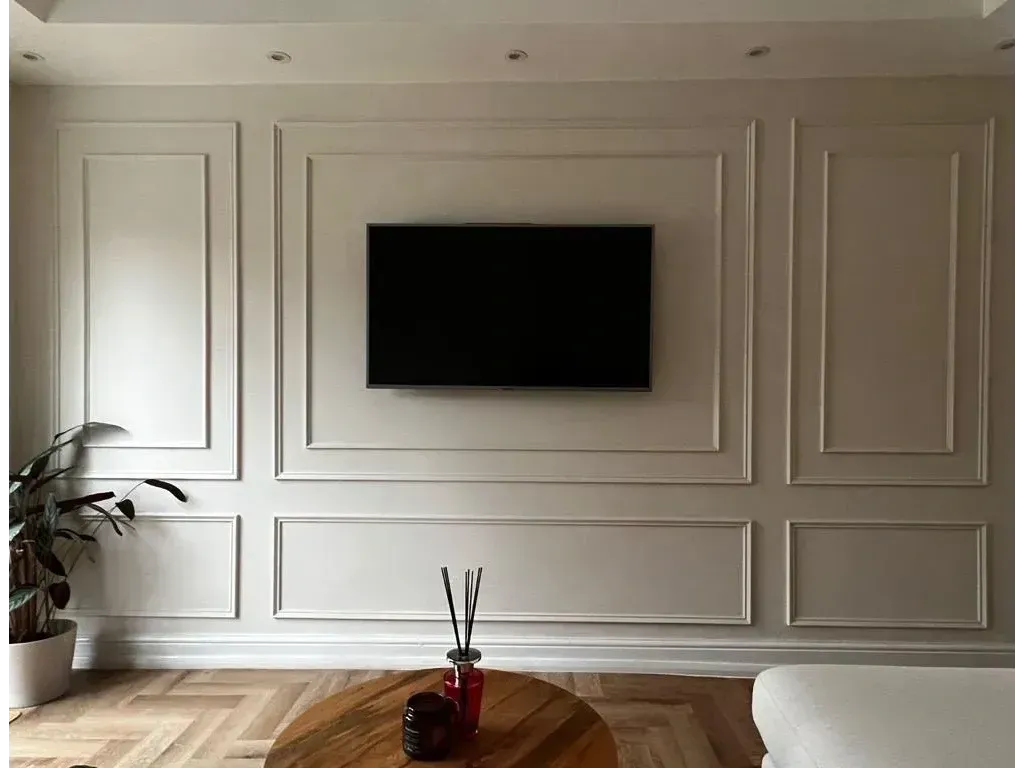 A living room with a flat screen tv mounted to the wall.
