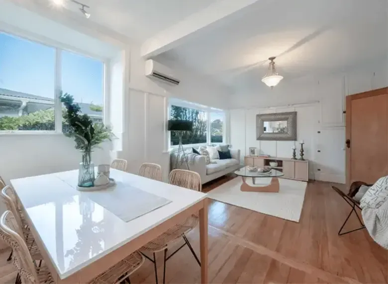 A living room with a table and chairs and a couch.