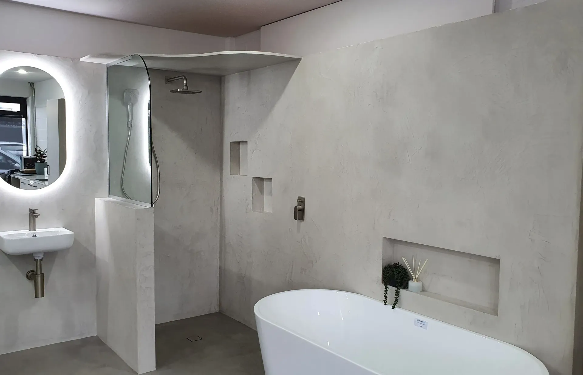 A bathroom with a bathtub , sink , shower and mirror.