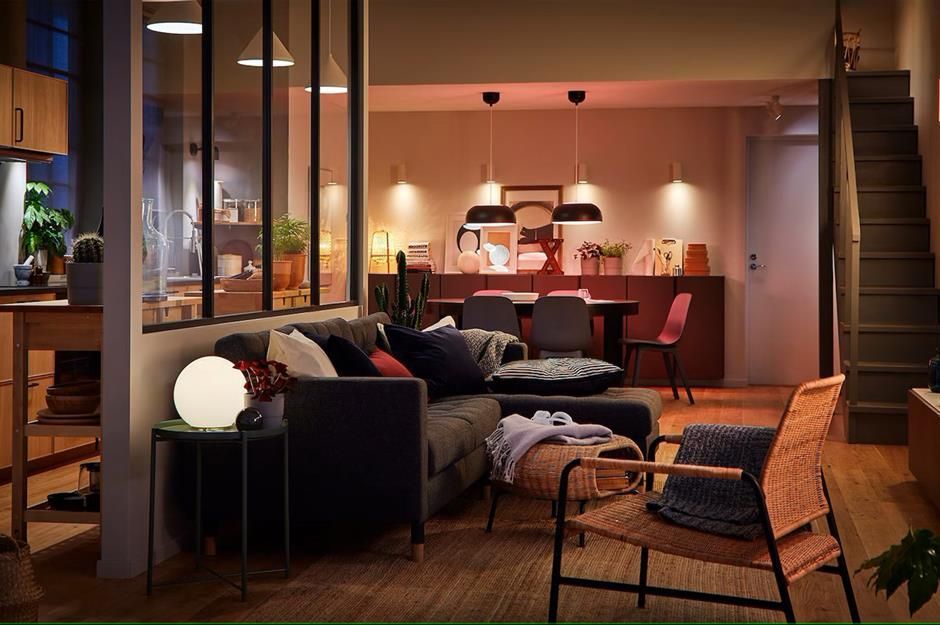 A living room with a couch , chair , table and stairs.