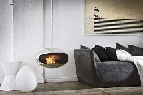 A living room with a couch and a fireplace hanging from the ceiling