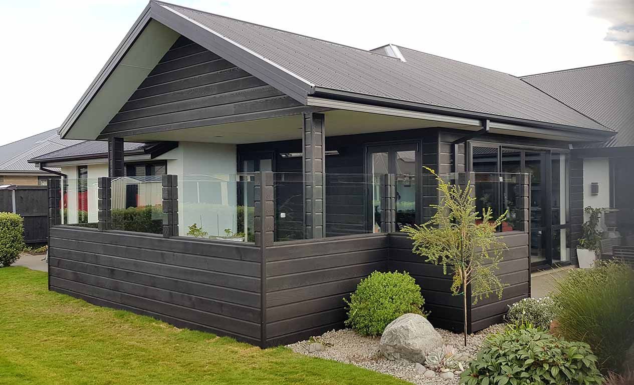A house with a balcony and a fence in front of it.