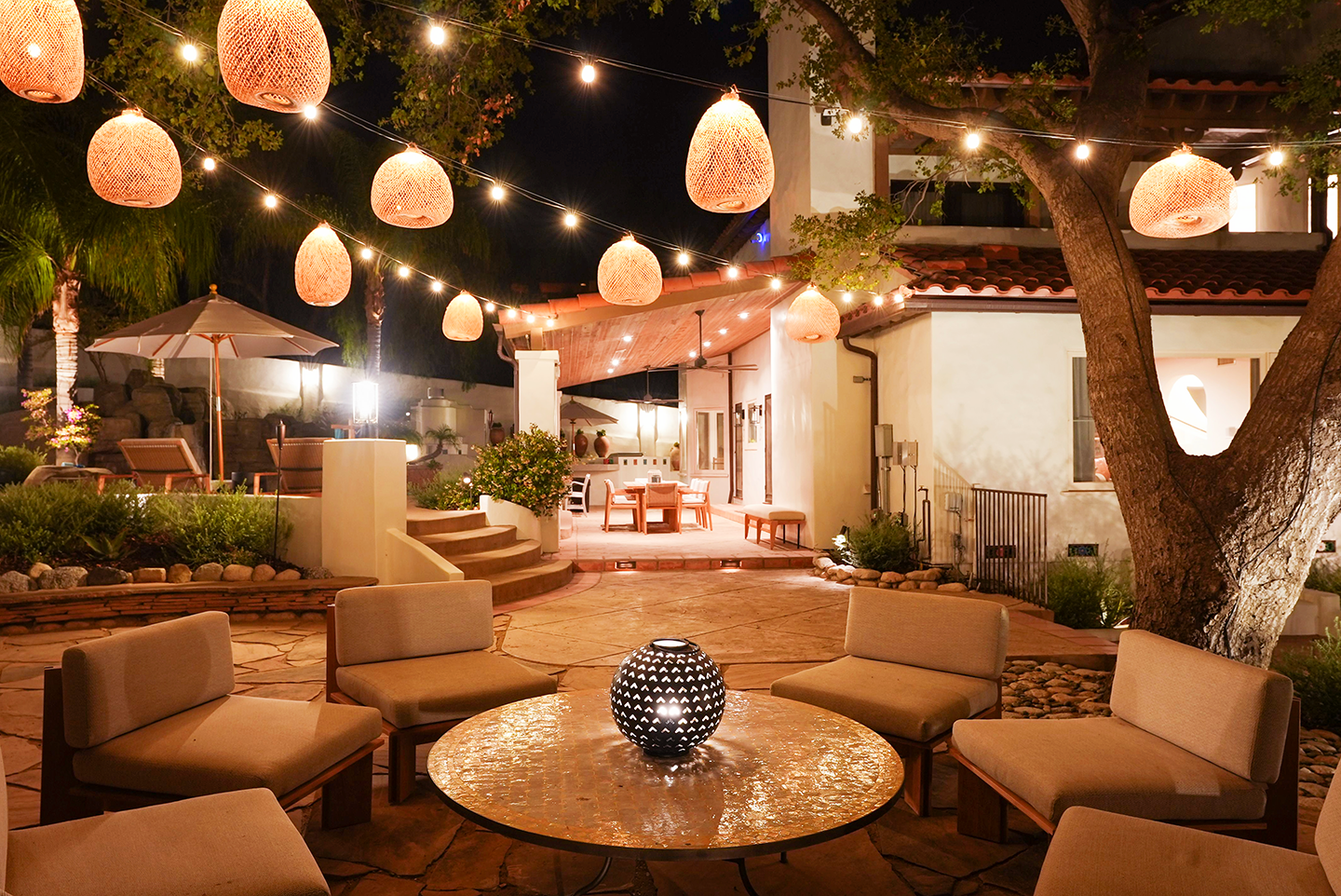 A patio area with chairs and a table at night