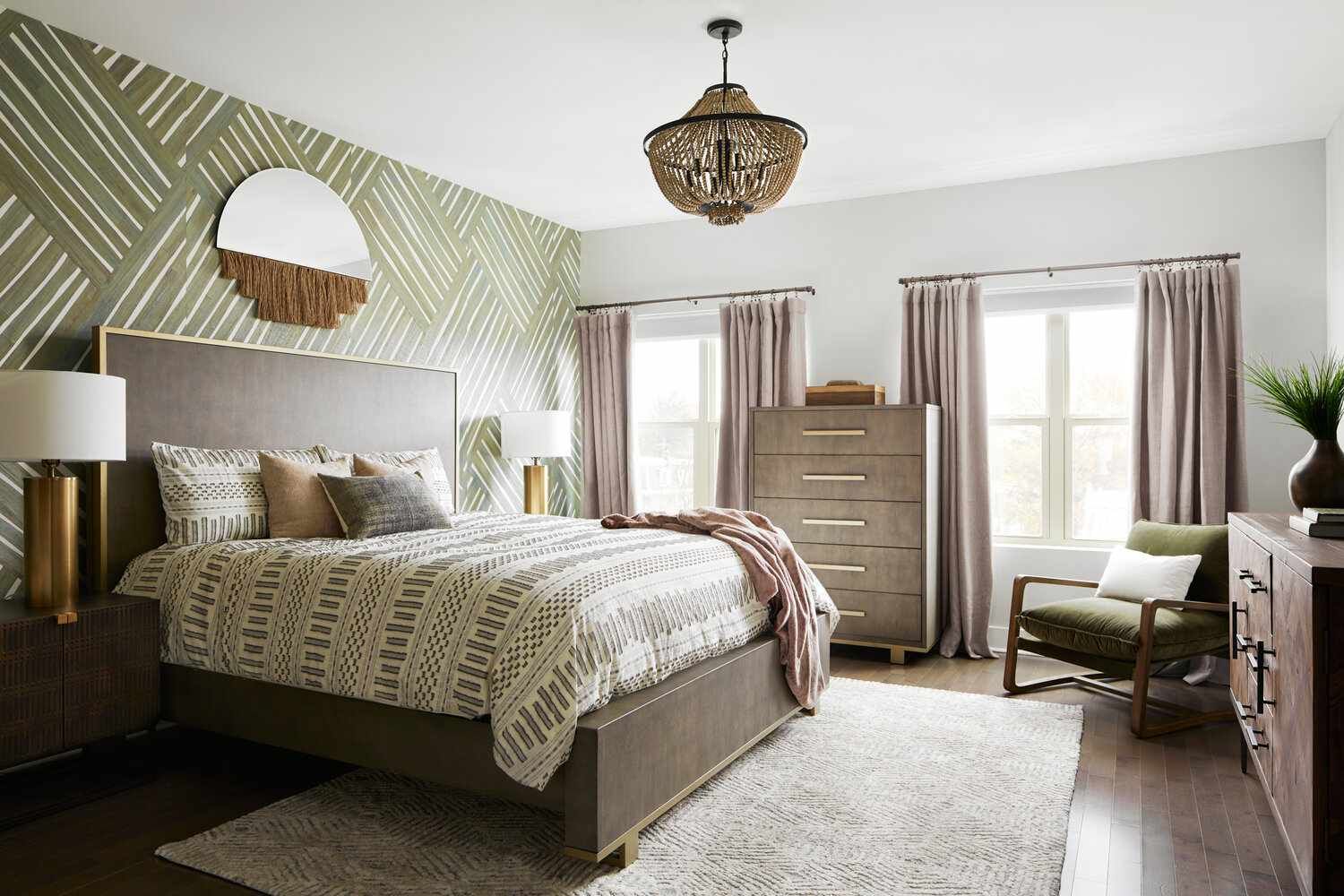 A bedroom with a bed , dresser , chair , and chandelier.