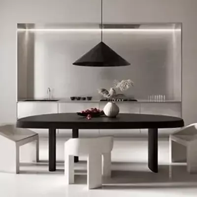 A black and white photo of a dining room with a table and chairs.