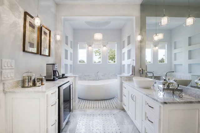 A bathroom with two sinks , a tub and a mirror.