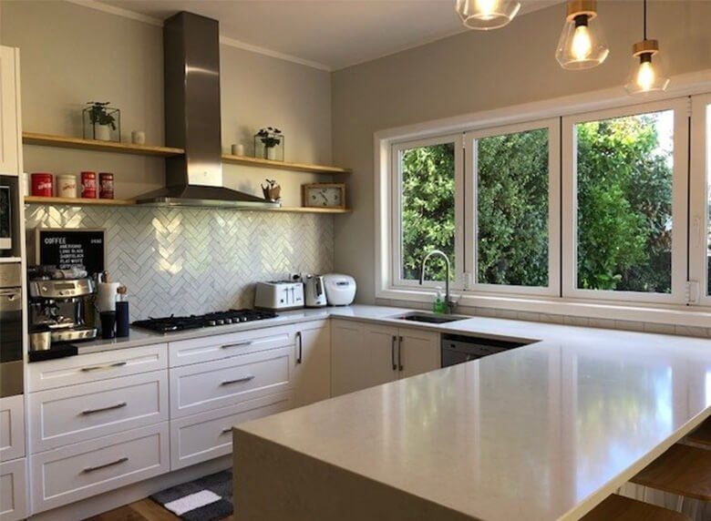 A kitchen with white cabinets and stainless steel appliances