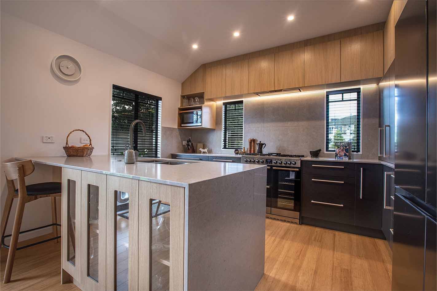Modern kitchen with wood cabinets, island, stainless appliances, and warm lighting