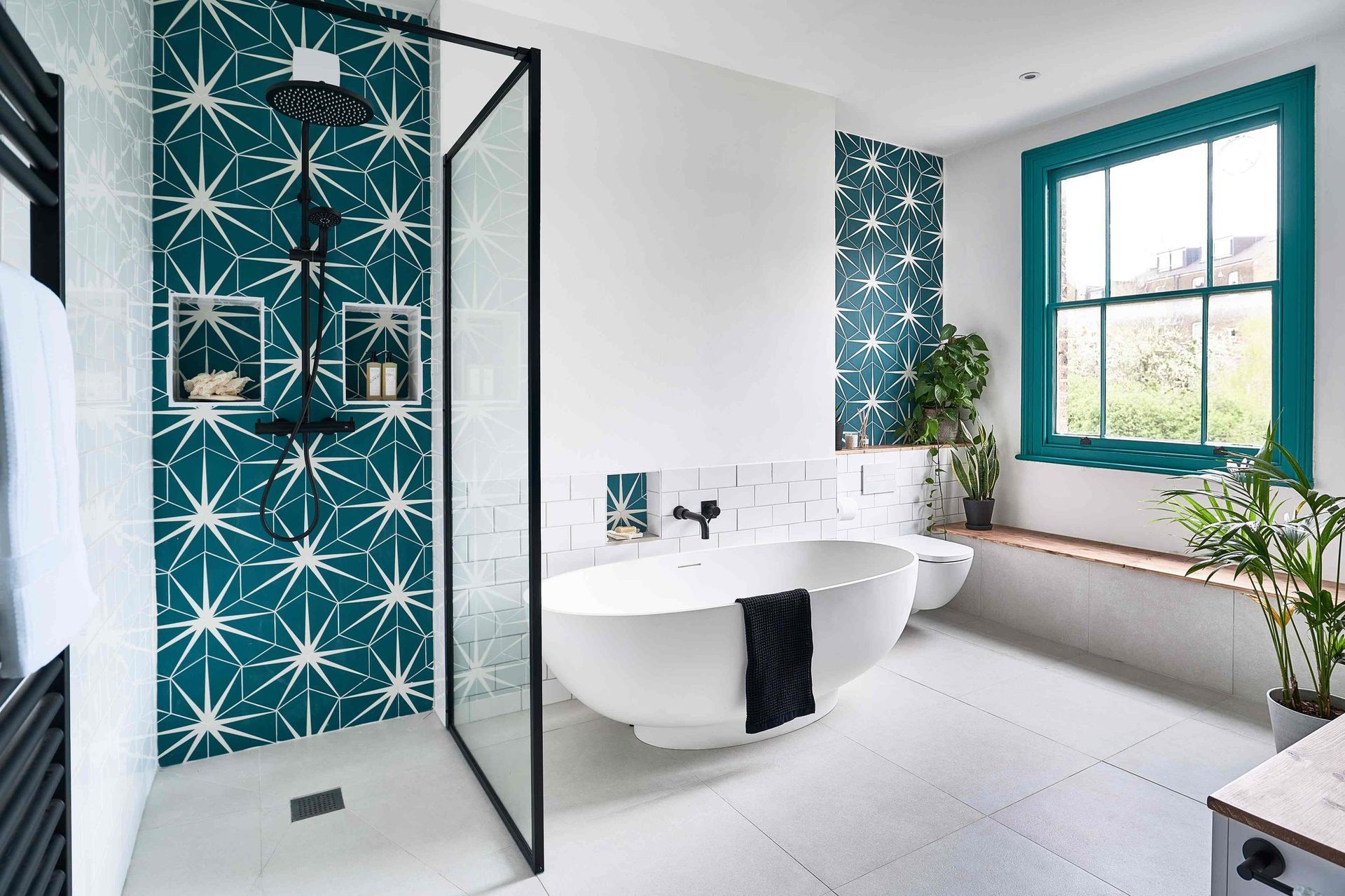 A bathroom with a bathtub , shower , and window.