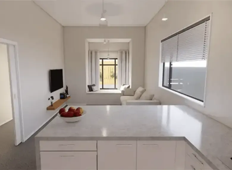 Bright modern kitchen opening to a living room with white cabinets, a fruit bowl, TV, and sofa.