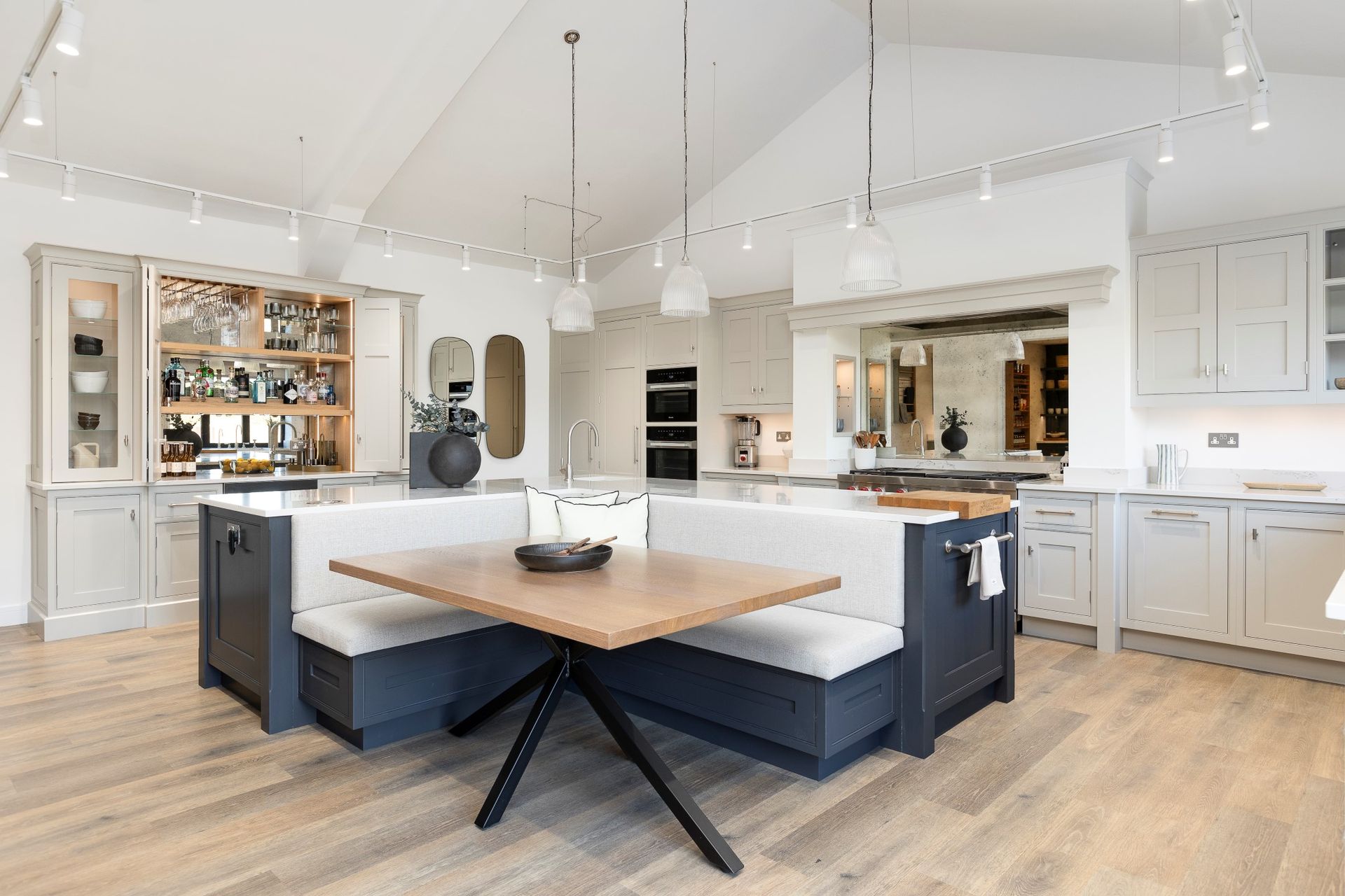 A kitchen with a table and benches in it.