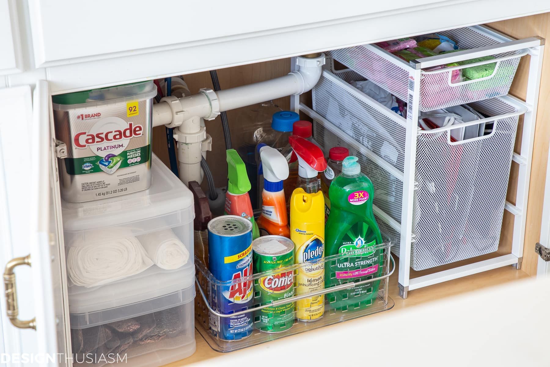 A kitchen sink with a lot of cleaning supplies underneath it.