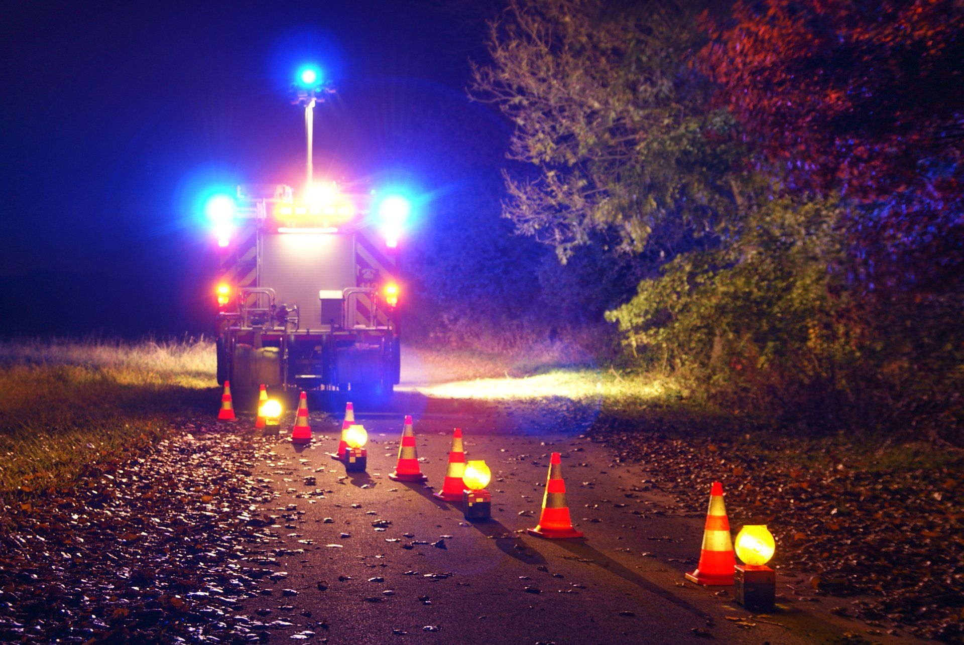 A fire truck is parked on the side of the road at night.