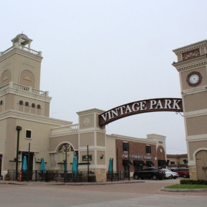 Vintage Park shopping center entrance with arched sign, beige buildings, and a clock tower