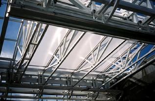 Looking up at the ceiling of a building with a blue sky in the background.