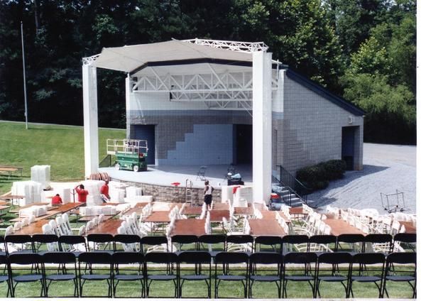 A large white building with a stage and chairs in front of it