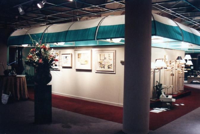 A room with a green and white awning and paintings on the wall
