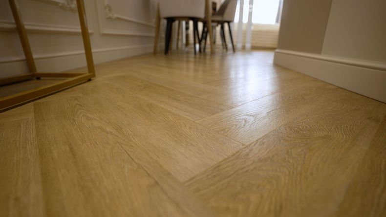 Herringbone pattern wood floor in a room.