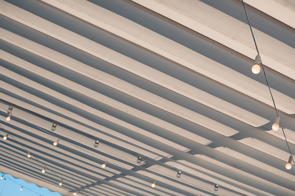 A large, black and white striped awning with lit-up string lights attatched to the outdoor shade near Lewiston & Moscow, ID and Clarkston & Pullman, WA