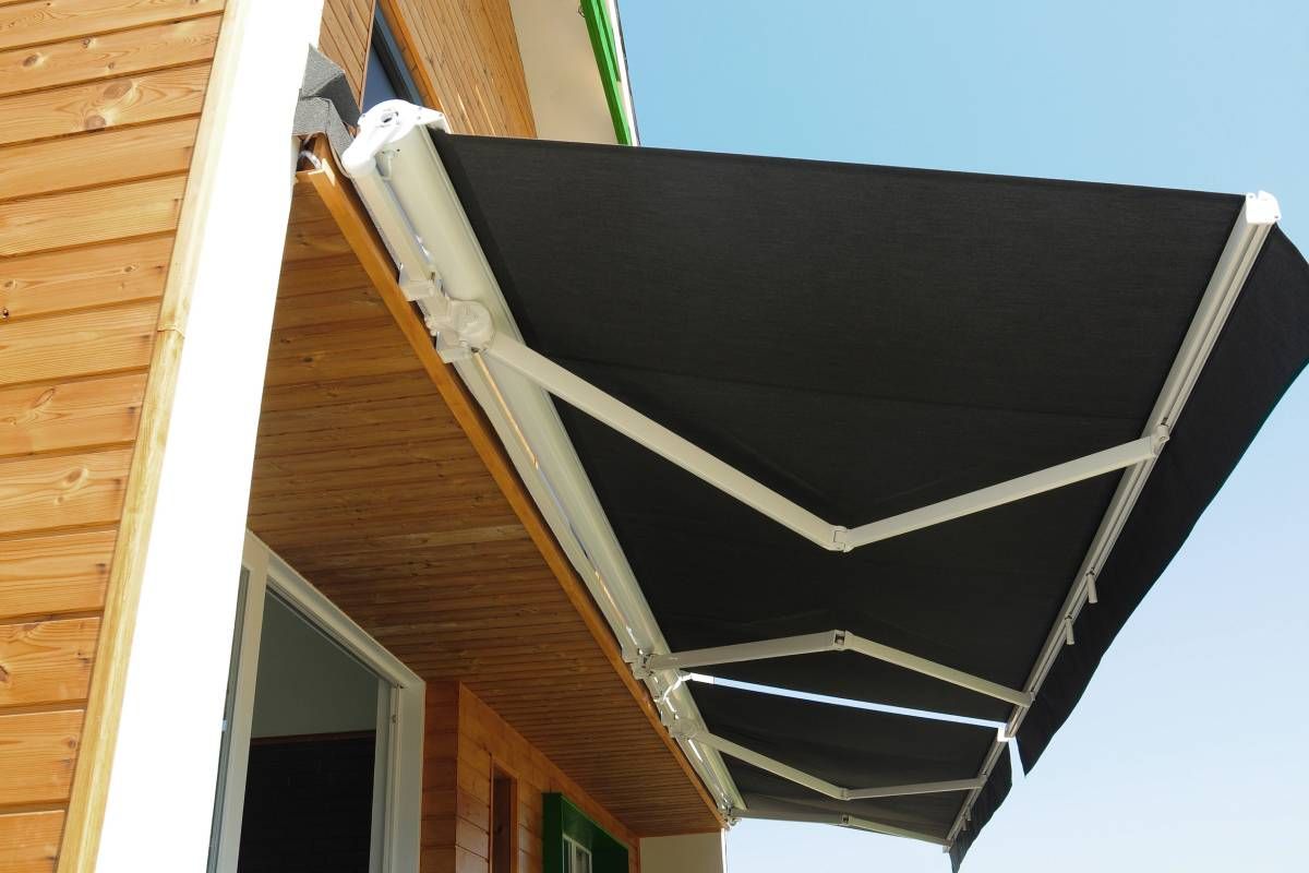 A smaller retractable awaning with black fabric and white hardware, attached to a cabin-inspired home near Lewiston & Moscow, ID and Clarkston & Pullman, WA