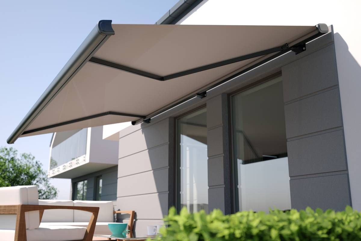 Outdoor retractable awning with black hardware details attatched to a modern-looking home with patio furniture near Lewiston & Moscow, ID and Clarkston & Pullman, WA
