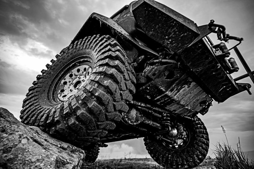 A Black And White Photo Of A Jeep Driving Down A Rocky Hill — Carson's Car Care In Armidale, NSW