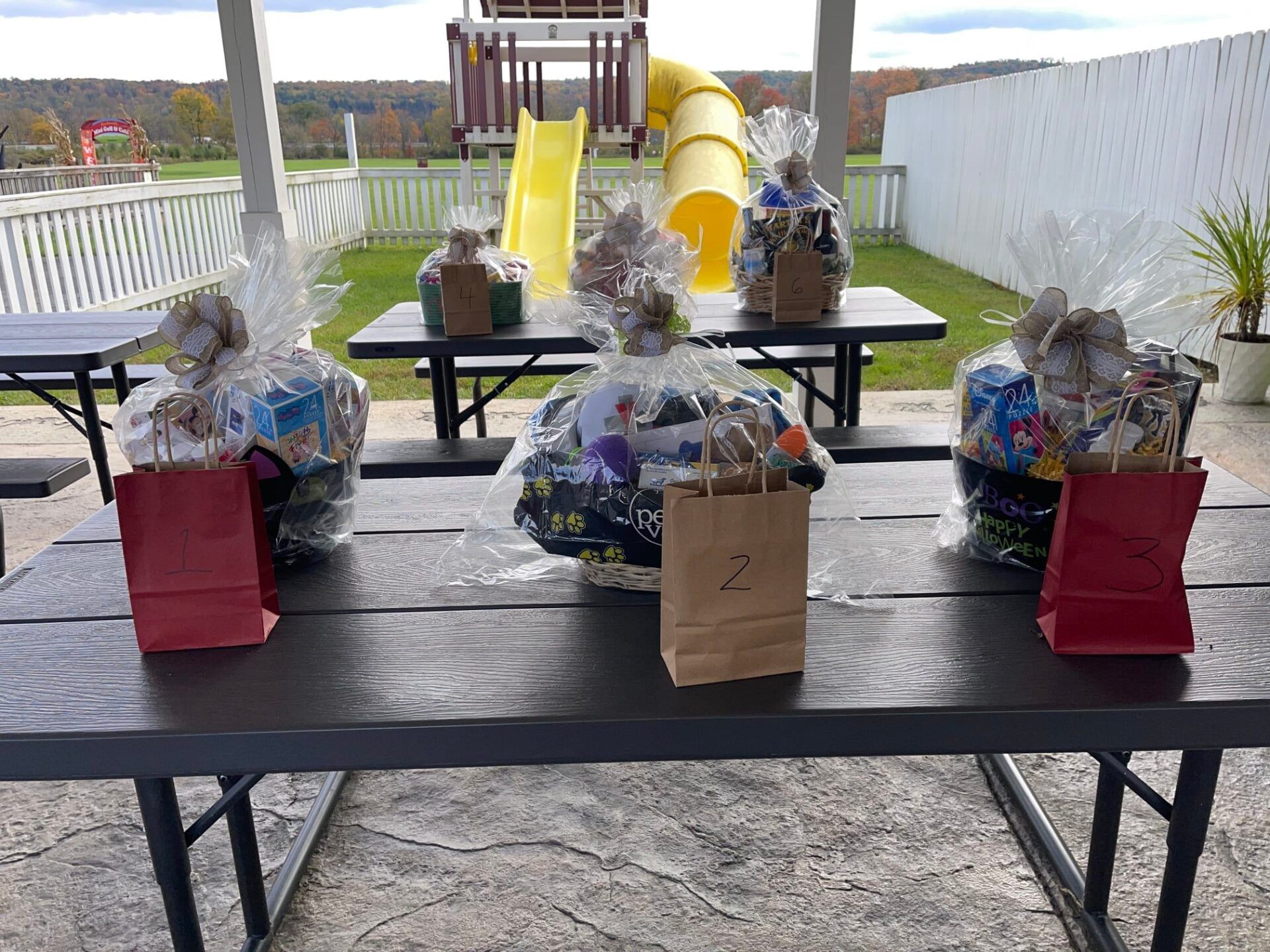 A picnic table with baskets on it and a slide in the background.