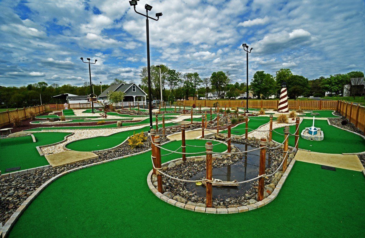 A golf course with a lot of green grass and trees in the background.