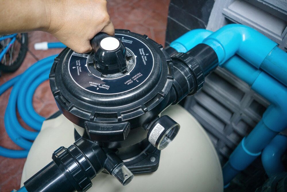 A Person is Working on a Swimming Pool Filter — Tweed Pool Shop in Kingscliff, NSW
