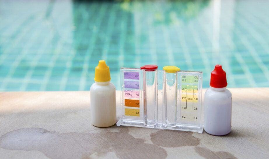 A Bottle of Chemicals is Sitting Next to a Swimming Pool — Tweed Pool Shop in Casuarina, NSW