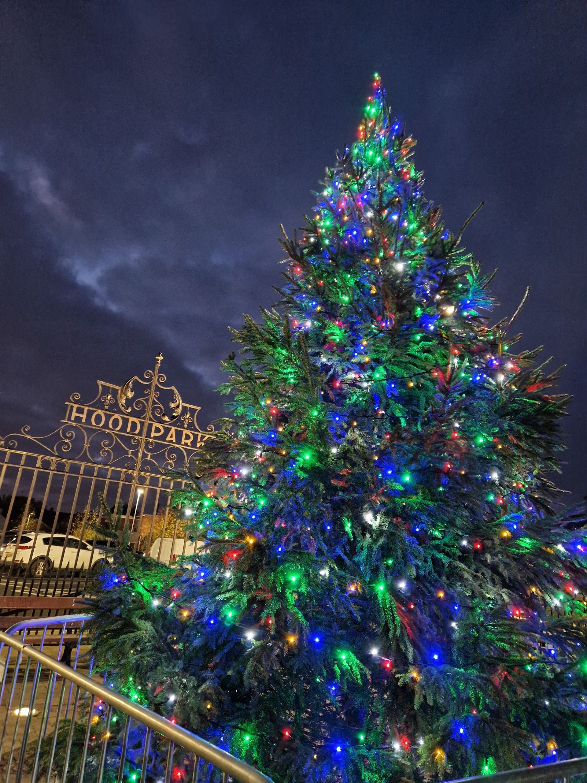A large christmas tree with lots of lights is lit up at night.