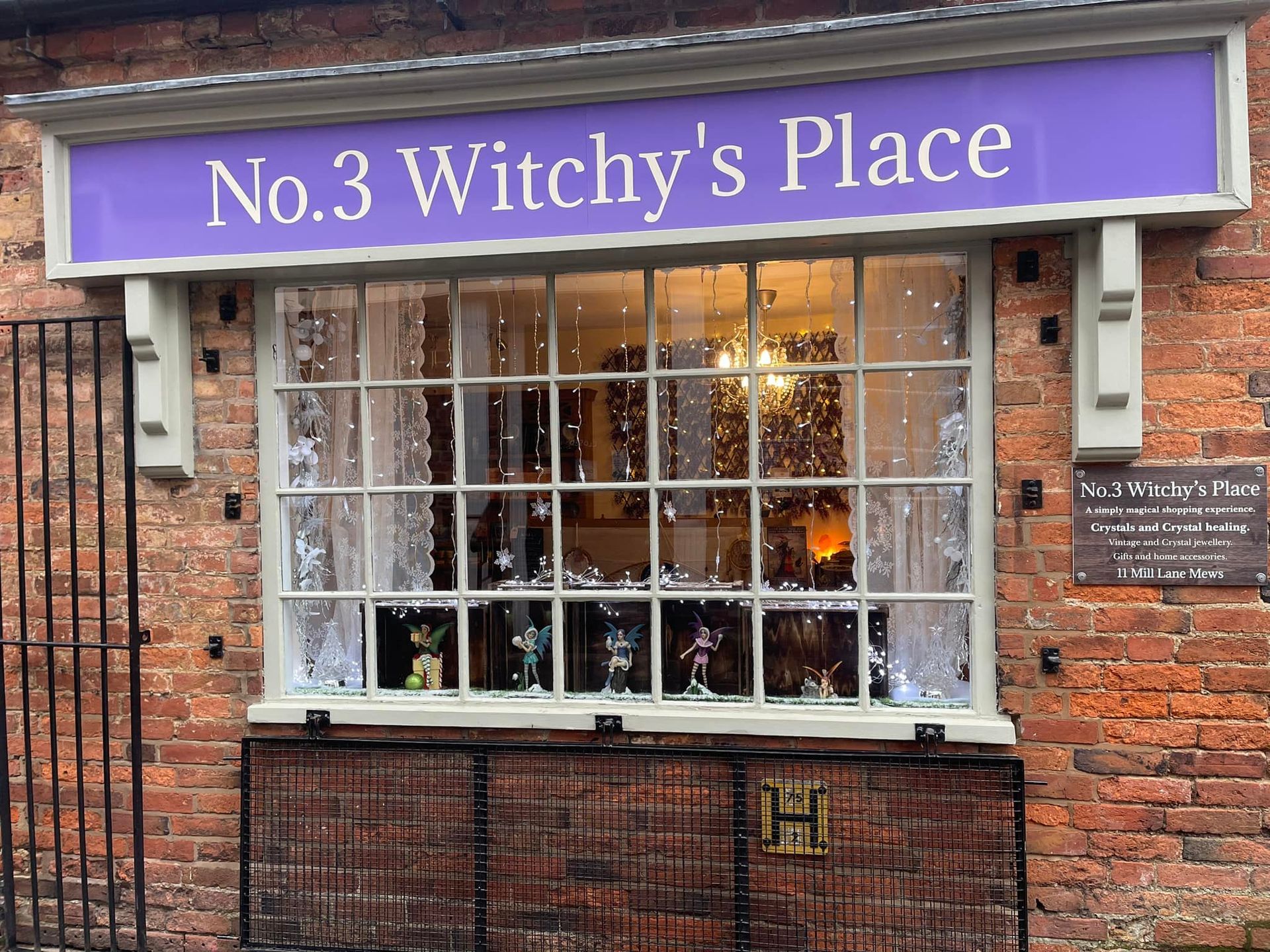 A brick building with a purple sign that says no.3 witchy 's place