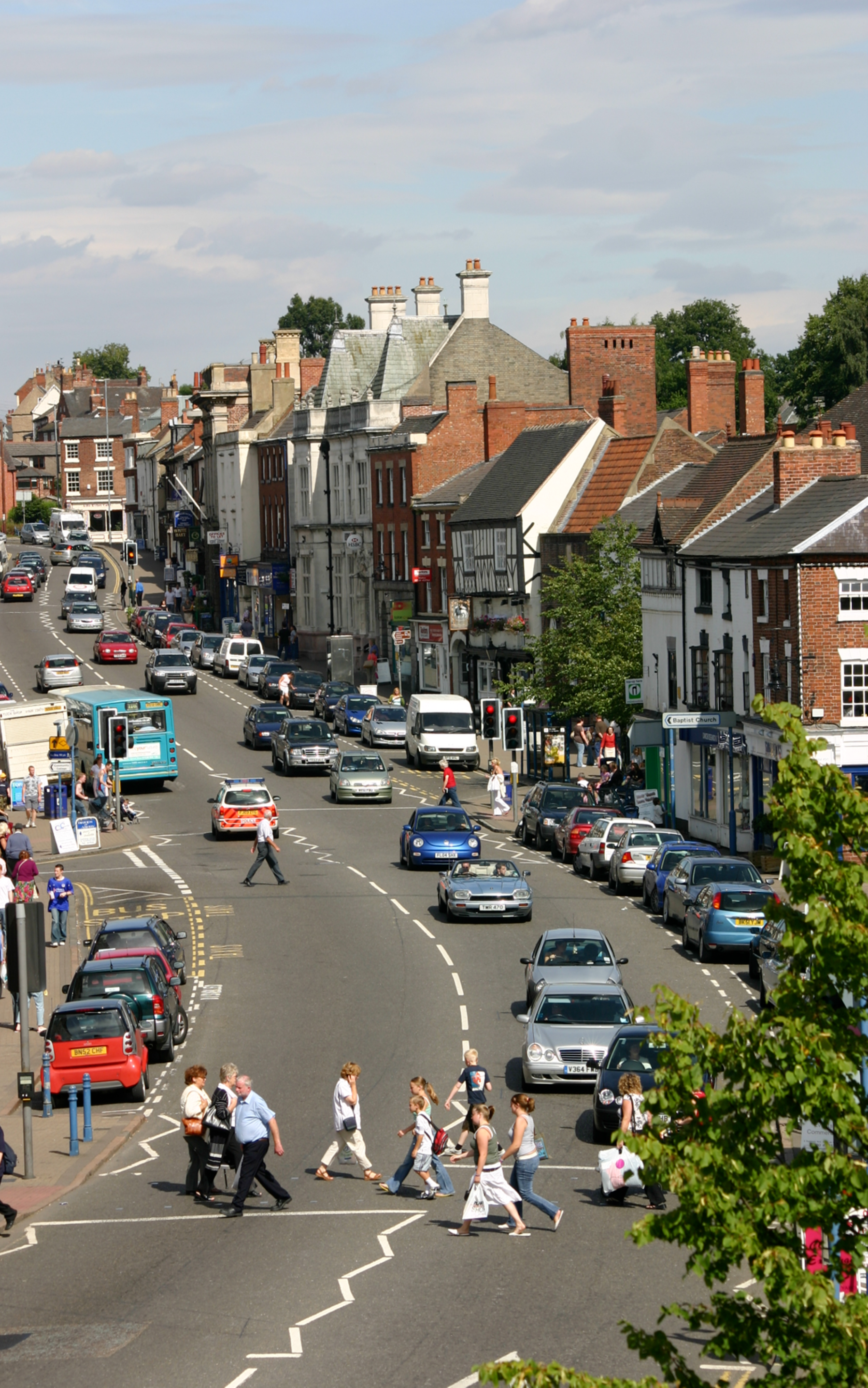 A busy street with cars parked on the side of it