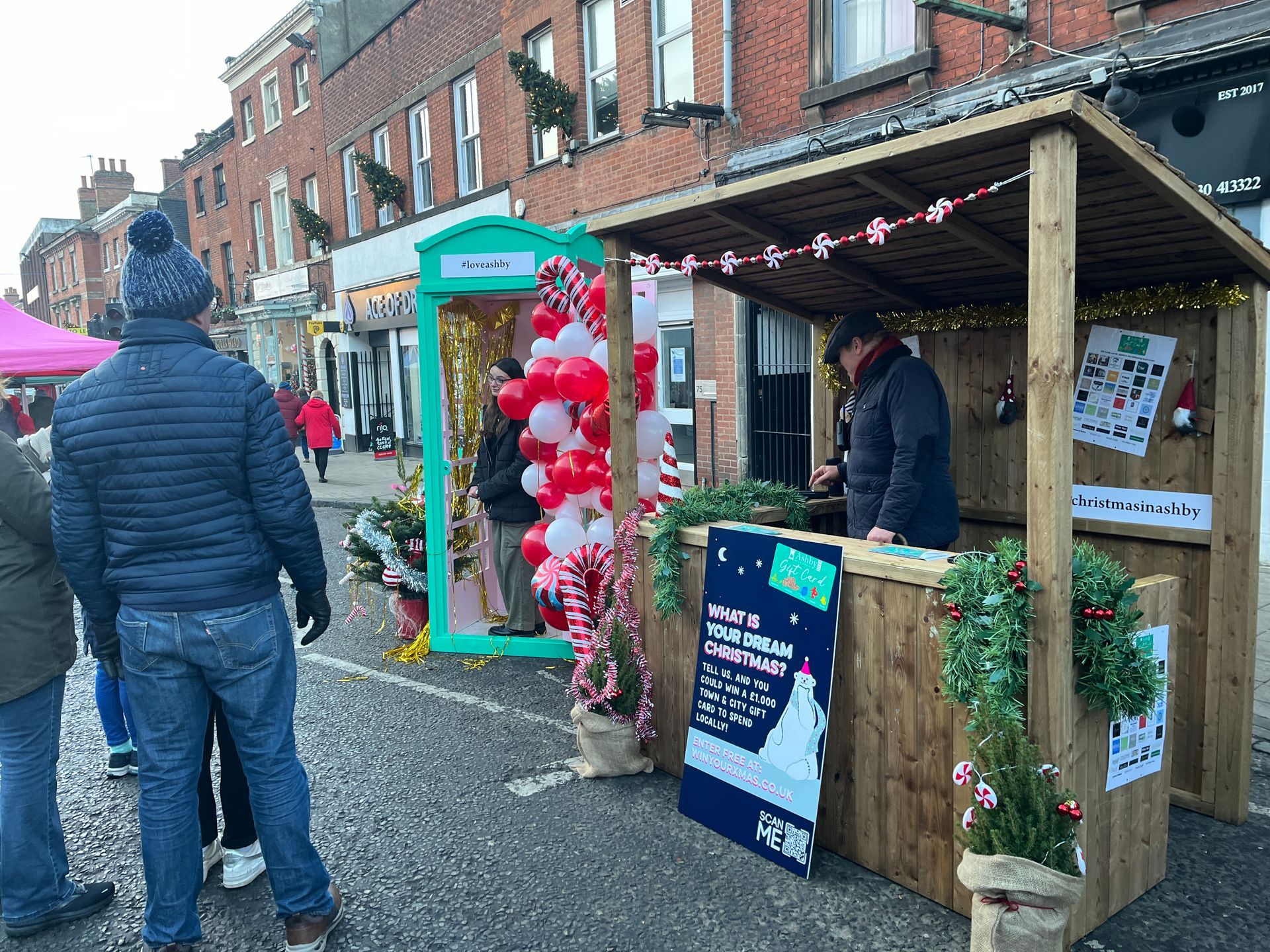 A group of people are standing in front of a christmas market.